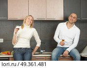 A pair laughs and drinks wine on a kitchen. Pair with wine. Стоковое фото, агентство Ingram Publishing / Фотобанк Лори
