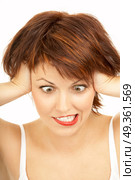 The cross-eyed woman with the tousled hair grimaces on a white background. Shock. Стоковое фото, агентство Ingram Publishing / Фотобанк Лори