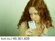 The thoughtful girl holds in a hand of a tablet and reflects on the developed situation. Condition of a hopelessness. Стоковое фото, агентство Ingram Publishing / Фотобанк Лори