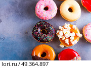 sweet doughnuts on gray stone background. sweet doughnuts top view border on gray stone background with copy space. Стоковое фото, агентство Ingram Publishing / Фотобанк Лори