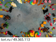 Colorful halloween candies on stone. Trick and treat - colorful halloween candies frame on gray stone with copy space. Стоковое фото, агентство Ingram Publishing / Фотобанк Лори