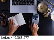 Workspace hero header with law gavel. Workspace hero header with law gavel, legal book and laptop keyboard, open empty notebook with someones hands doing calculations, top view flatlay scene. Стоковое фото, агентство Ingram Publishing / Фотобанк Лори