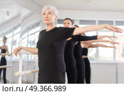 Girls in ballet class perform second position with participation of mature female mentor. Стоковое фото, фотограф Яков Филимонов / Фотобанк Лори