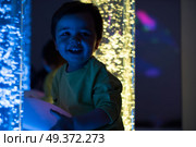 Young kid exploring snoezelen space. Young kid exploring a multi sensory space - snoezelen concept. Стоковое фото, агентство Ingram Publishing / Фотобанк Лори