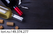 Bottles of red and white wine with corks on dark wooden table. Glass of red wine. Стоковое фото, агентство Ingram Publishing / Фотобанк Лори