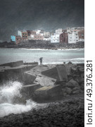 Puerto de la Cruz. fisherman standing on the dock and goes fishing. Big waves. Стоковое фото, агентство Ingram Publishing / Фотобанк Лори
