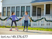 Teen girls group rolling skate in the street outdoor. Стоковое фото, агентство Ingram Publishing / Фотобанк Лори