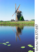traditional dutch windmill with reflection in canal at Kinderdijk at summer day, Netherland. dutch windmill over river waters. Стоковое фото, агентство Ingram Publishing / Фотобанк Лори