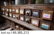Wooden drawer cabinet filled with labeled storage boxes in a quaint workshop setting. Стоковое AI-изображение, AI-художник Сергей Толмачёв / Фотобанк Лори