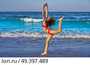 acrobatic gymnastics bikini girl in a beach blue shore at summer. Стоковое фото, агентство Ingram Publishing / Фотобанк Лори
