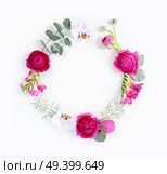 Flowers composition. Round frame made of dried eucaliptus leaves and flowers on white background. Flat lay, top view, copy space. Flowers flat lay composition. Стоковое фото, агентство Ingram Publishing / Фотобанк Лори