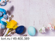 Easter border with painted blue eggs, rabbits and flowers on aged wooden desktop. Easter frame with painted eggs and flowers. Стоковое фото, агентство Ingram Publishing / Фотобанк Лори