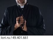 Priest praying hands with rosary beads male. Стоковое фото, агентство Ingram Publishing / Фотобанк Лори