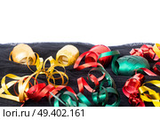 Carnaval festive decorations isolated borer over white background with copy space. Carnaval decorations on dark wooden background. Стоковое фото, агентство Ingram Publishing / Фотобанк Лори