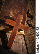 Christian cross on wood bible and rosary beads over wooden vintage background. Стоковое фото, агентство Ingram Publishing / Фотобанк Лори