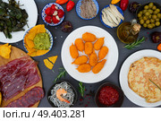 Table with plates of spanish tapas - jamon, croquetes, guacamole and olives, top view, picnic table. Table with spanish tapas. Стоковое фото, агентство Ingram Publishing / Фотобанк Лори