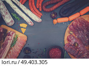 spanish tapas with salami, chorizo, lomo, jamon with red hol salsa sause and olives, picnic table, top view frame with copy space, retro toned. Picnic table with spanish sausage tapas. Стоковое фото, агентство Ingram Publishing / Фотобанк Лори