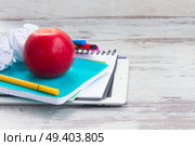 Apple with school supplies on white aged wooden table. Apple with school supplies. Стоковое фото, агентство Ingram Publishing / Фотобанк Лори