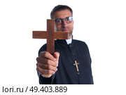 Priest holding cross of wood praying in foreground. Стоковое фото, агентство Ingram Publishing / Фотобанк Лори