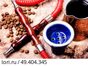 Stylish coffee jezva with coffee and hookah mouthpiece.Arabian shisha and coffee.Shisha Concept. Hookah with aroma coffee. Стоковое фото, агентство Ingram Publishing / Фотобанк Лори