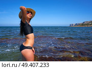 Bikini girl in summer Mediterranean beach having fun with beach hat. Стоковое фото, агентство Ingram Publishing / Фотобанк Лори
