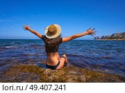 Bikini girl in summer Mediterranean beach having fun sit open arms excited. Стоковое фото, агентство Ingram Publishing / Фотобанк Лори