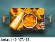 Bottle with healthy energetic drink and word smoothie for cold season with orange ingredients : pumpkin, persimmon , orange fruits, ginger and turmeric or curcuma powder in tray, top view. Clean food. Стоковое фото, агентство Ingram Publishing / Фотобанк Лори