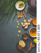 Healthy turmeric spice tea on gray background with teapot, cup of tea and ingredients:  lemon,  ginger, cinnamon sticks and honey , top view.  Immune boosting remedy , detox and dieting concept. Стоковое фото, агентство Ingram Publishing / Фотобанк Лори