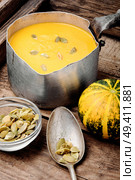 Autumn pumpkin soup in a metal saucepan. Autumn food. Pumpkin cream soup in bowl. Стоковое фото, агентство Ingram Publishing / Фотобанк Лори
