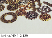 A steampunk and ancient macro about machinery made of bronze, silver and gold gears with beige background. Стоковое фото, агентство Ingram Publishing / Фотобанк Лори