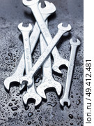Set of wrenches in water drops on black metal. Стоковое фото, агентство Ingram Publishing / Фотобанк Лори