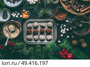 Homemade vegan chocolate truffle pralines for Christmas with dried fruits and nuts mix ingredients on dark background, top view, border. Healthy sweets. Energy vegan balls with dates, cocoa and almond. Стоковое фото, агентство Ingram Publishing / Фотобанк Лори