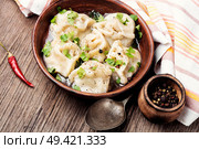 Traditional Russian dish pelmeni.Meat dumplings on wooden rustic background. Homemade meat dumplings. Стоковое фото, агентство Ingram Publishing / Фотобанк Лори