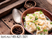 Traditional Russian dish pelmeni.Meat dumplings on wooden rustic background. Homemade meat dumplings. Стоковое фото, агентство Ingram Publishing / Фотобанк Лори