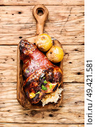 Roasted pork knuckle on wooden cutting board.Oktoberfest menu.. Roasted pork knuckle. Стоковое фото, агентство Ingram Publishing / Фотобанк Лори