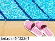 A pair of womens plastic sandals by side of swimming pool. Стоковое фото, агентство Ingram Publishing / Фотобанк Лори