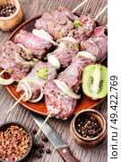 Fresh raw beef meat fillet shish kebab on skewers.Kiwi soaked meat. Raw shish kebab. Стоковое фото, агентство Ingram Publishing / Фотобанк Лори