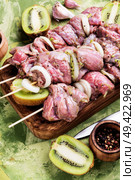 Fresh raw beef meat fillet shish kebab on skewers.Kiwi soaked meat.Long banner. Raw shish kebab. Стоковое фото, агентство Ingram Publishing / Фотобанк Лори