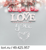 Word love with roses border on pastel blue background, top view with copy space . Valentines day or abstract love concept. Стоковое фото, агентство Ingram Publishing / Фотобанк Лори