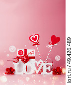Valentines day background. Composition With Love message, gift box, red ribbons and hearts lollipops. Festive greeting concept. Romantic Love declaration concept. Copy space for your design. Стоковое фото, агентство Ingram Publishing / Фотобанк Лори