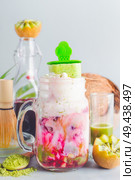 Fusion matcha green tea latte in glass jar with matcha ice popsicle. Matcha espresso fusion drink with pink fruits juice. Healthy antioxidants, detox and weight loss beverage. Vegan summer food. Стоковое фото, агентство Ingram Publishing / Фотобанк Лори