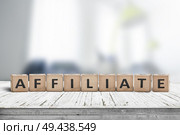 Affiliate marketing sign on a wooden desk with a blurry office environment in the background. Стоковое фото, агентство Ingram Publishing / Фотобанк Лори