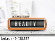 Time for beauty message on a retro alarm clock in a bright living room. Стоковое фото, агентство Ingram Publishing / Фотобанк Лори