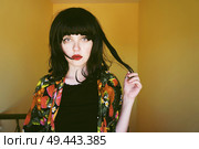 Beautiful brunette woman in a yellow room in her home                                . Стоковое фото, агентство Ingram Publishing / Фотобанк Лори