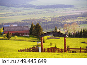 Rural green spring landscape. House and village on the hills. Fence with arch and Gate. Malopolska region in Poland. Стоковое фото, агентство Ingram Publishing / Фотобанк Лори