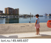 Little girl looking at the Port of Malaga in Andalusia, Spain.. Little girl looking at the Port of Malaga. Стоковое фото, агентство Ingram Publishing / Фотобанк Лори
