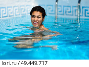 Happy young woman relaxing in swimming pool. Smiling girl with healthy tanned skin and wet hair enjoying Summer Sun at pool edge.. Happy young woman relaxing in swimming pool. Стоковое фото, агентство Ingram Publishing / Фотобанк Лори