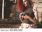 Young redhead photographer woman enjoying her passion outdoors. Стоковое фото, агентство Ingram Publishing / Фотобанк Лори