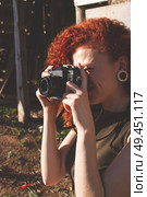 Young redhead photographer woman enjoying her passion outdoors. Стоковое фото, агентство Ingram Publishing / Фотобанк Лори