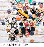 Spools of threads and buttons on wooden table.Scissor, sewing buttons and thread. Sewing tools and accessories. Стоковое фото, агентство Ingram Publishing / Фотобанк Лори